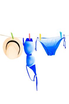 swimsuit bikini and straw hat drying on the clothesline