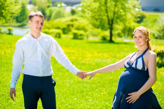 active couple waiting for a baby, shooting in the summer park