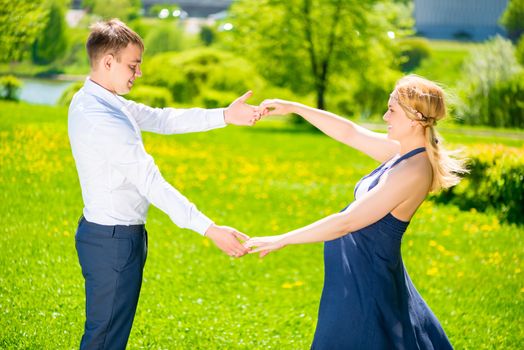 beautiful young couple in the park, woman is pregnant