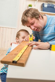 father teaches his son carpentry in the garage