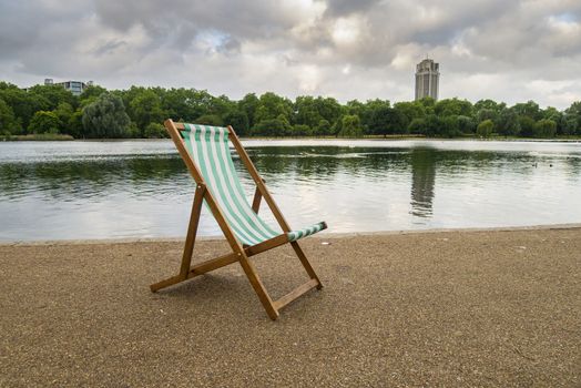 A lone deck chair early in the morning by the Serpentine, Hyde Park, London