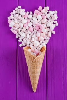 Marshmallows heart and waffle cones on a purple background