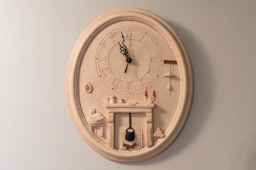 antique earthen wall clock beige hanging on a white wall