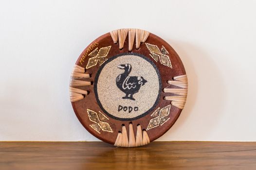 old African carved wooden plate on a wooden table on a background of the wall