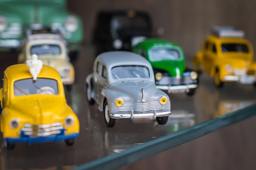 Colorful retro sport toy cars on a glass stand