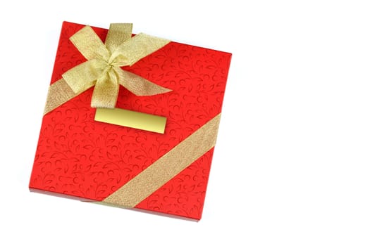 Red gift with blank label and decorated with gold ribbon isolated on a white background