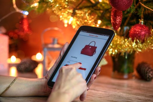 Woman makes Christmas shopping via smartphone in the online e-store