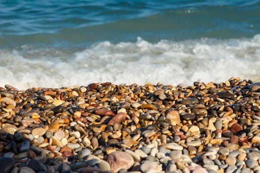 Sea shore with round stones on the mediterranean coast. Horizontal image.