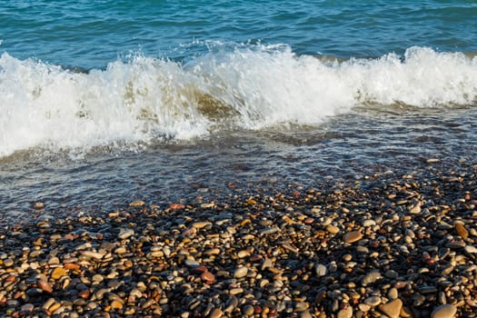 Sea shore with round stones on the mediterranean coast. Horizontal image.