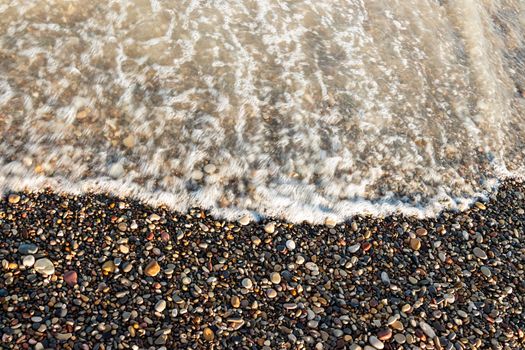 Sea shore with round stones on the mediterranean coast. Horizontal image.