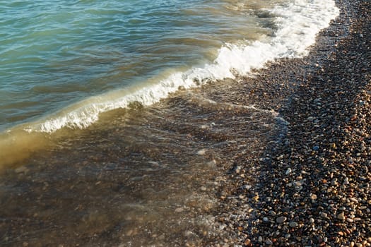 Sea shore with round stones on the mediterranean coast. Horizontal image.