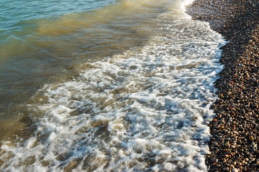 Sea shore with round stones on the mediterranean coast. Horizontal image.