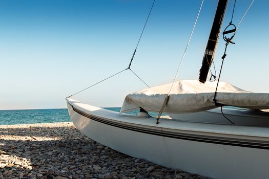 Catamaran on the beach on the stones. Horizontal image.