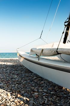 Catamaran on the beach on the stones. Vertical image.