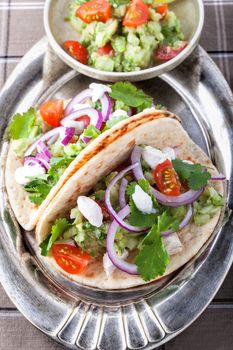 Chicken Tacos with vegetables on a pad.