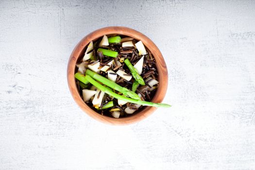 Black rice, apple, asparagus salad on a white background