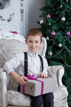 Boy with Christmas gift-box sitting