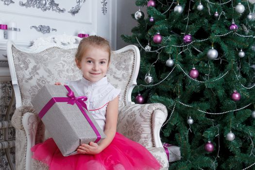 Pretty girl with gift-box under Christmas tree