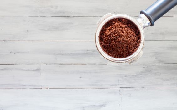 Coffee grind in group on white wooden wall texture background