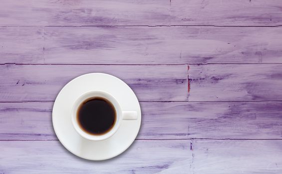 Top view of cup of fresh espresso on purple wooden background