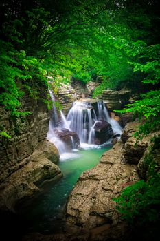 Cascade waterfall in the gorge. Woods around the river. Clear water. Georgia. Long exposure. Vignetting effect.