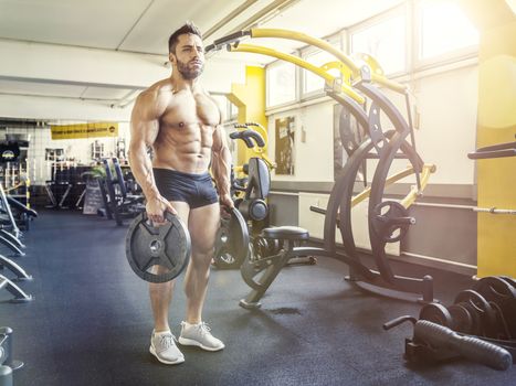 An image of a handsome bearded muscular man in the gym