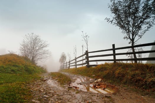 Muddy ground after rain in Carpathian mountains. Extreme path rural dirt road in the hills. Bad weather.