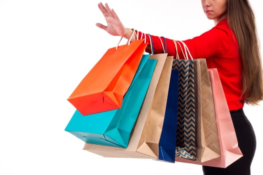 Colourful and bright shopping paper packages hanging on female red-sleeved arm