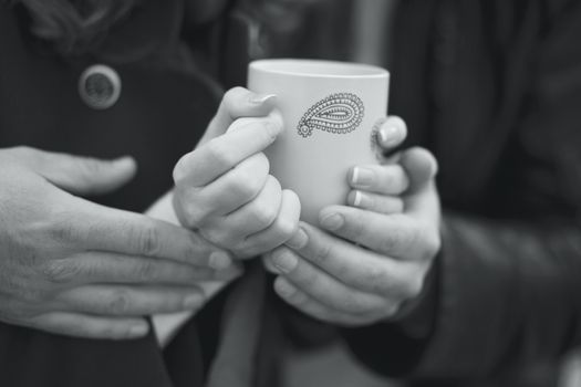Couple in love warming his hands on a cup of hot tea