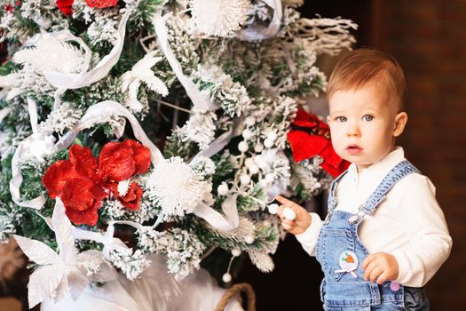 Little baby girl decorates a Christmas tree