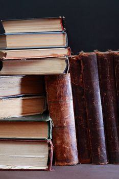 Stack of old books on blue background with free space