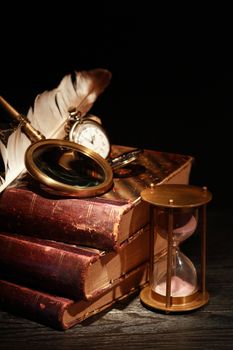 Vintage still life. Magnifying glass and pocket watch on old books