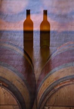 Reflection Bottle of wine and barrel on brown background, France