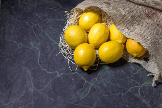 Fresh picked lemons spilling from a burlap sack. Horizontal format with copy space.