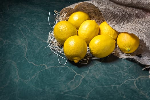 Fresh picked lemons spilling from a burlap sack. Horizontal format with copy space.