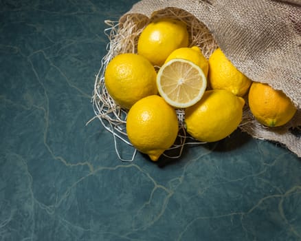 Fresh picked lemons spilling from a burlap sack. Horizontal format with copy space.