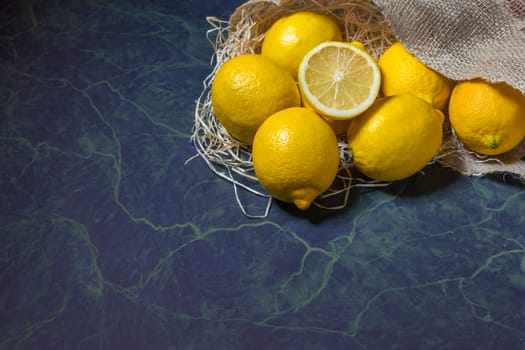 Fresh picked lemons spilling from a burlap sack. Horizontal format with copy space.