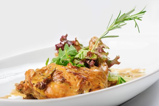 Baked and stewed rabbit legs with rosemary and lettuce