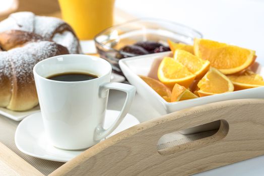 Shot on hotel's breakfast tray with croissants, coffee, oranges, juice, jam and cutlery