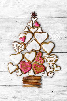 Christmas cookies are laid out in the shape of Christmas tree on light wooden background