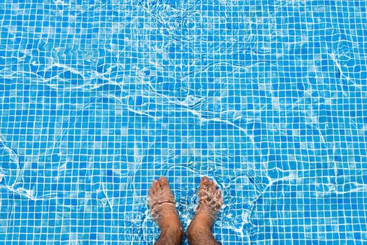 Bare feet cooling off in the pool relaxing concept