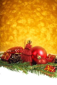 Christmas card with red baubles and gifts on golden bokeh light background with copyspace