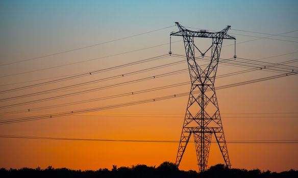 Electricity pylon making a silhouette against the setting sun