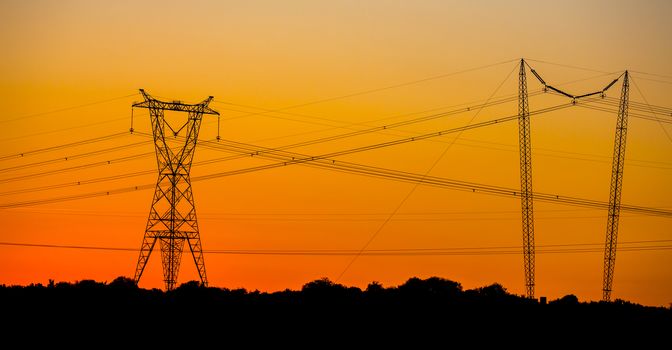 Electricity pylon making a silhouette against the setting sun