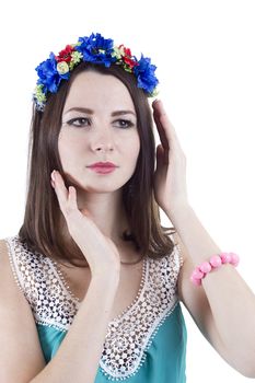 Portrait of a girl in a wreath of flowers on a white background