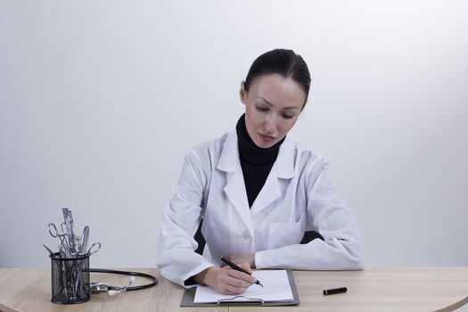 Young female doctor working at his desk