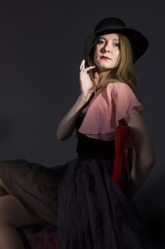 Portrait of a young woman in a hat on a black background