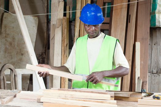 This carpenter takes the measure of his plates to have a uniform height of his tables.