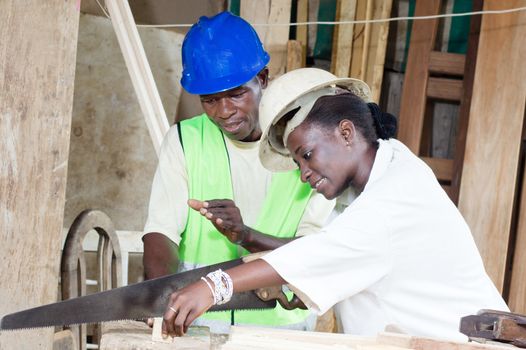 Young student learning to saw wood.