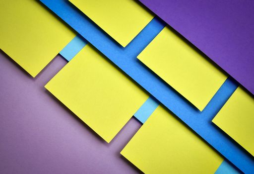 Yellow squares of tissue paper on a abstract dark background